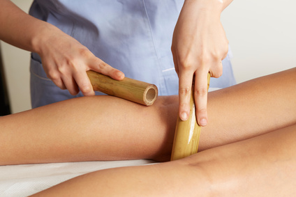 Woman having bamboo stick massage at day spa
